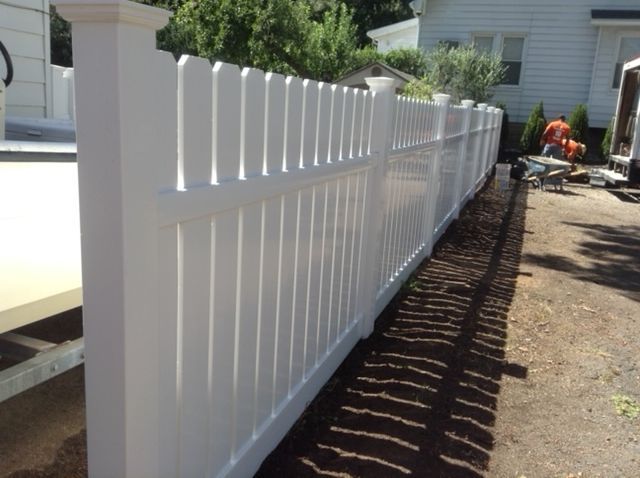 A white picket fence is being built in front of a house.