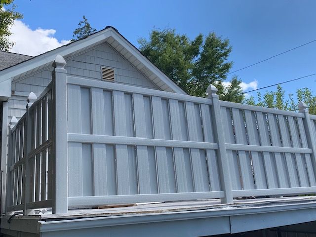 A white fence is sitting on the side of a house