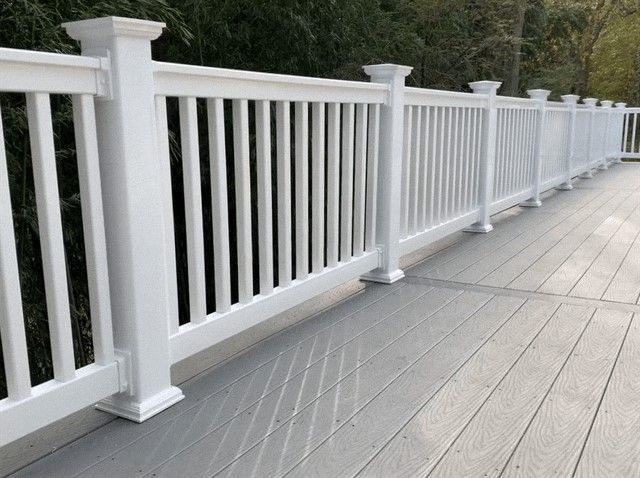 A white fence surrounds a wooden deck.