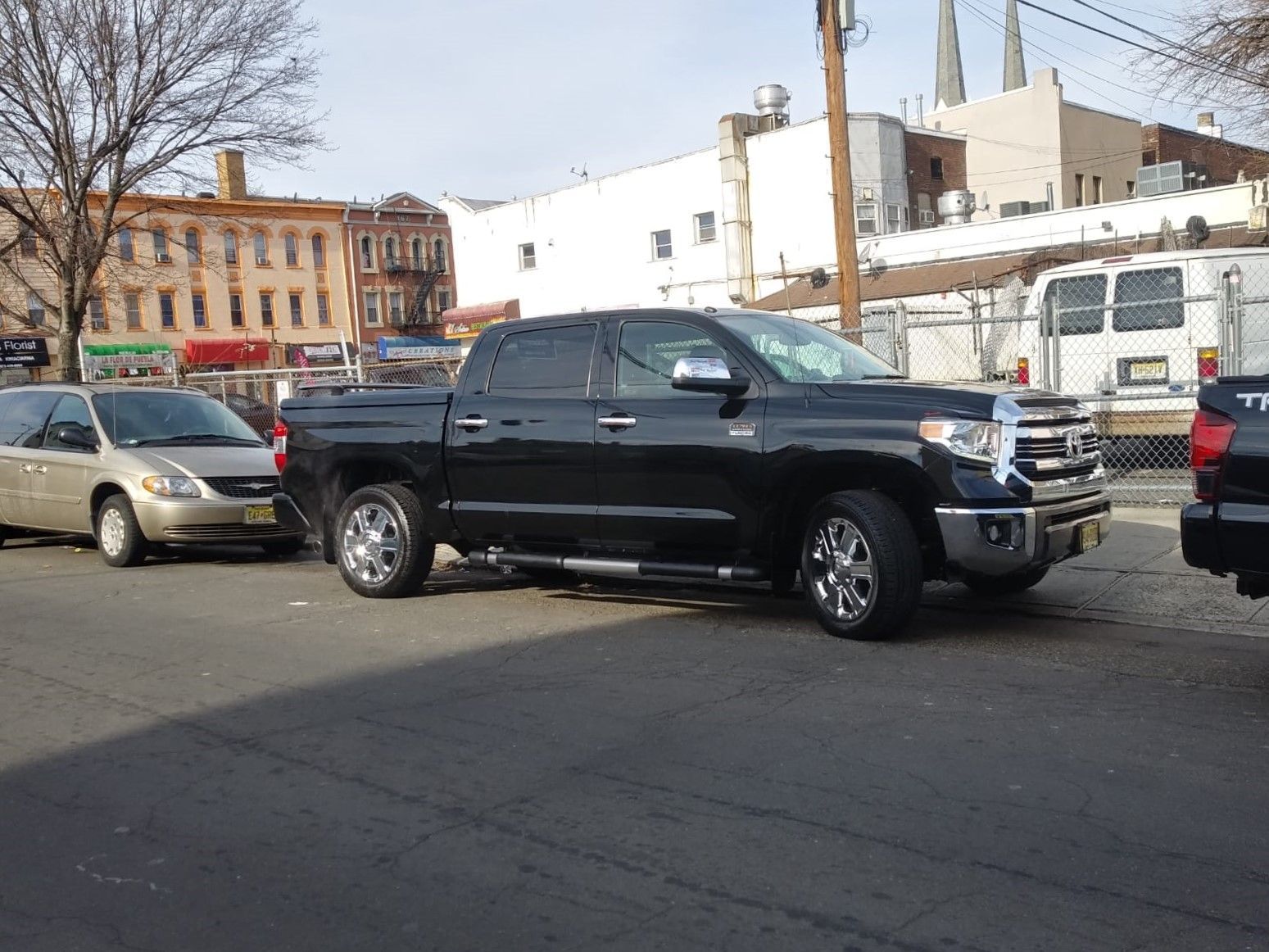 A black truck is parked on the side of the road