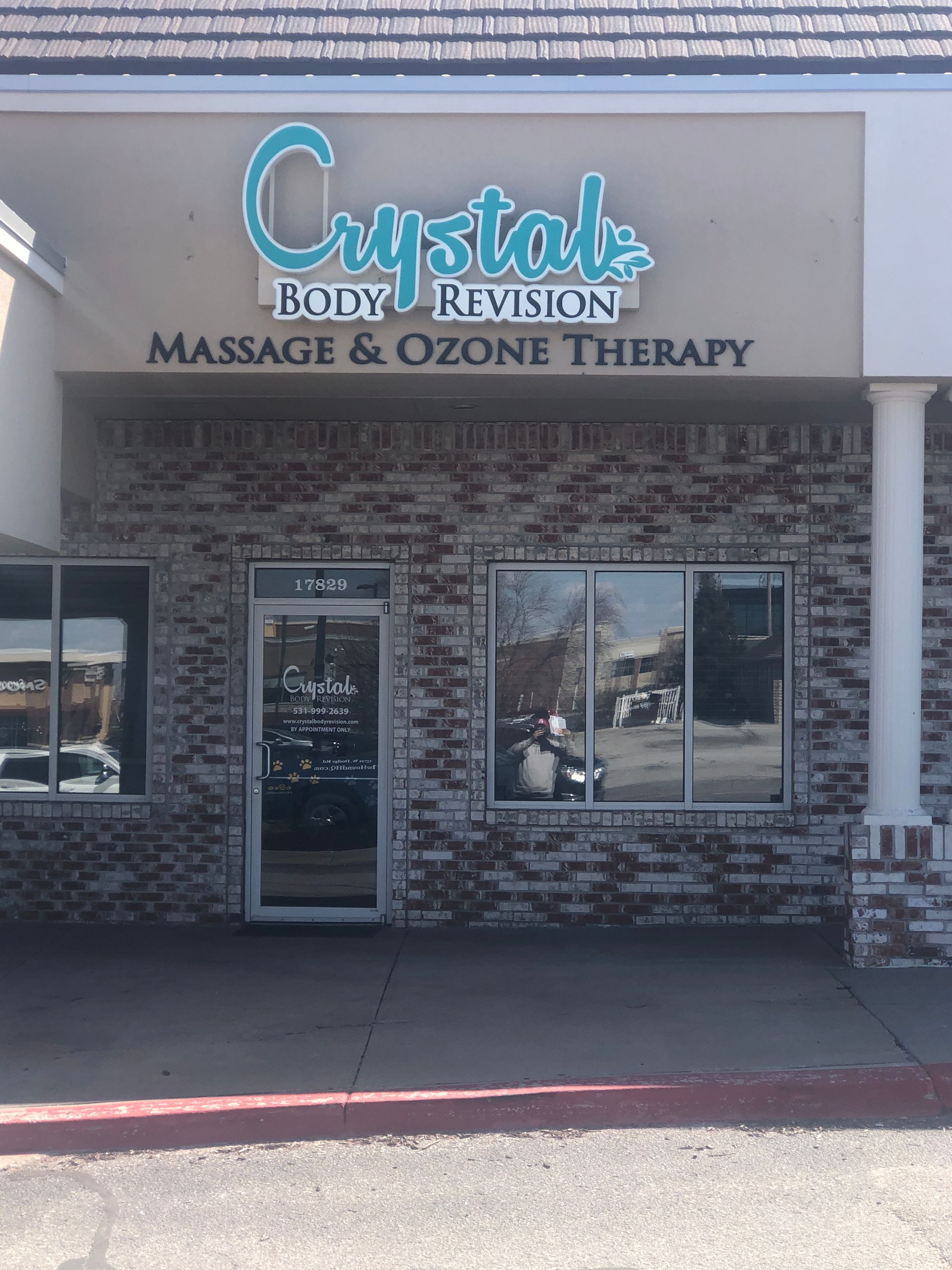 Storefront for Crystal Body Rejuvenation, massage and ozone therapy, with blue sign and brick facade