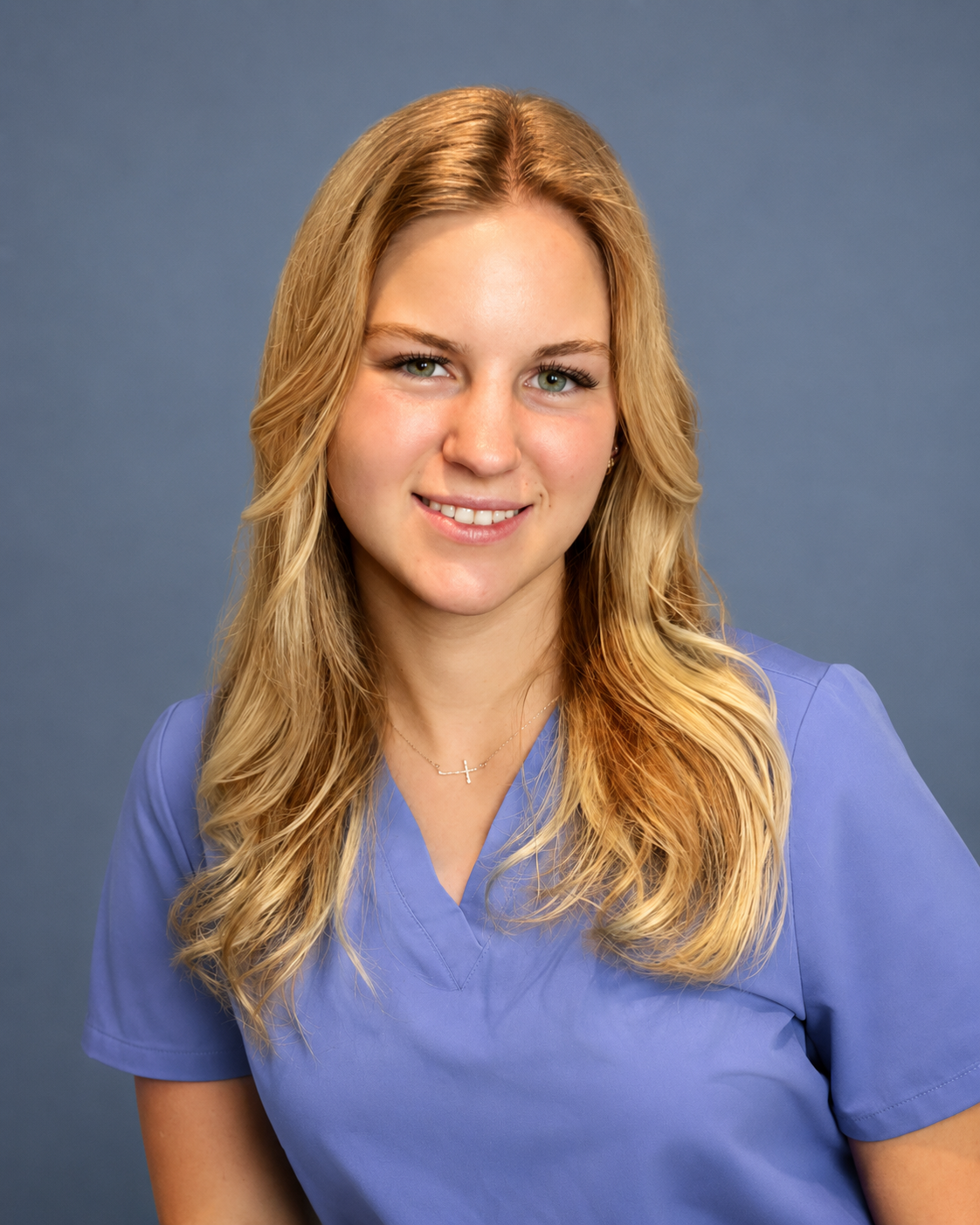 Smiling woman in a blue shirt against a plain blue background