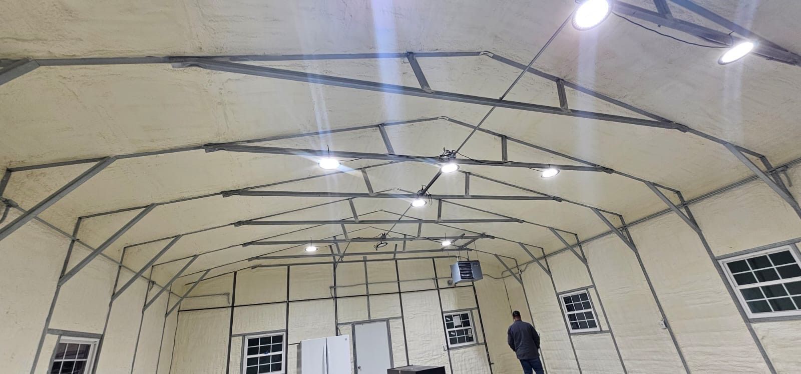 A man is standing in the middle of a large building.