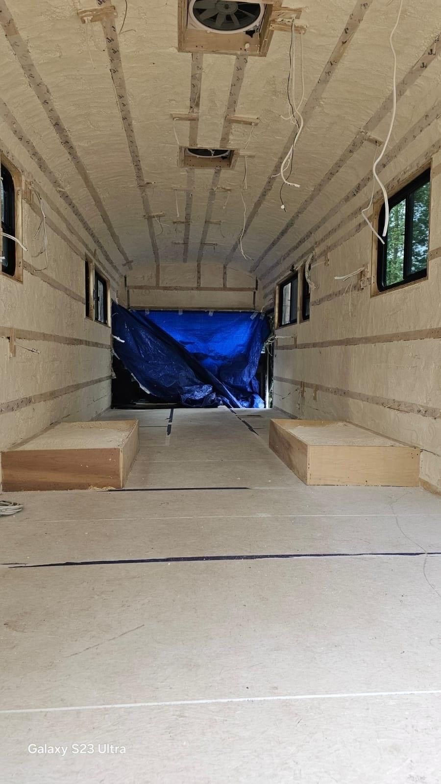 A large room with a lot of windows and a blue tarp on the ceiling.