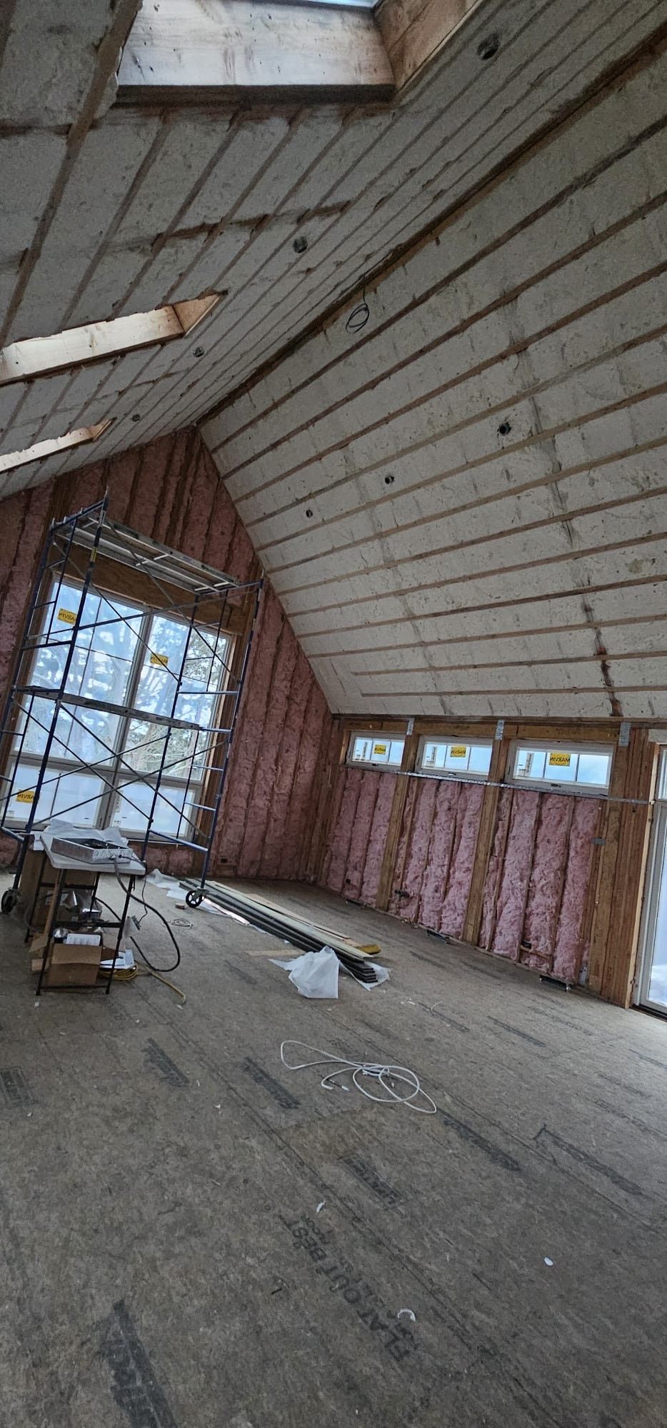 A large room with a lot of windows and insulation on the walls.