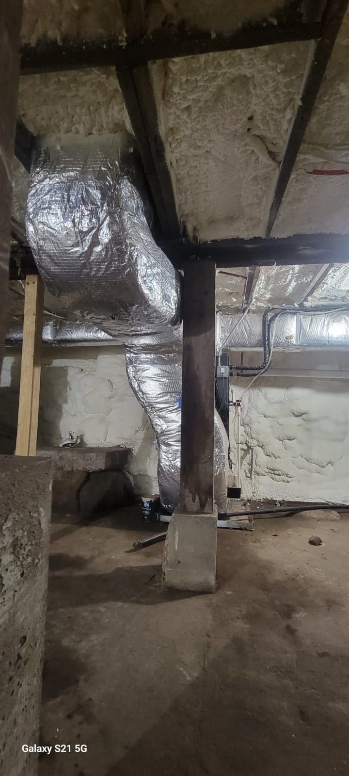 A picture of a basement with a lot of pipes coming out of it.