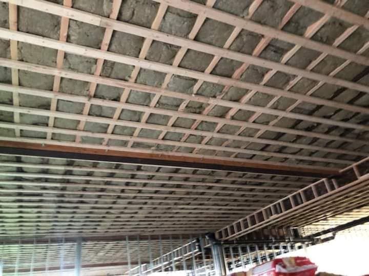 The ceiling of a building under construction with a lot of wooden beams.