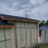 A shed is being insulated with foam and a roof.
