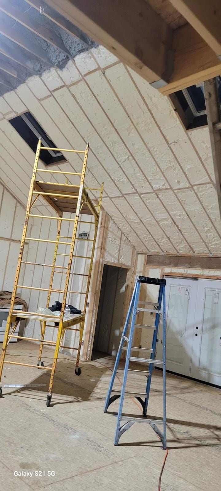 A room with a ladder and a scaffolding in it.