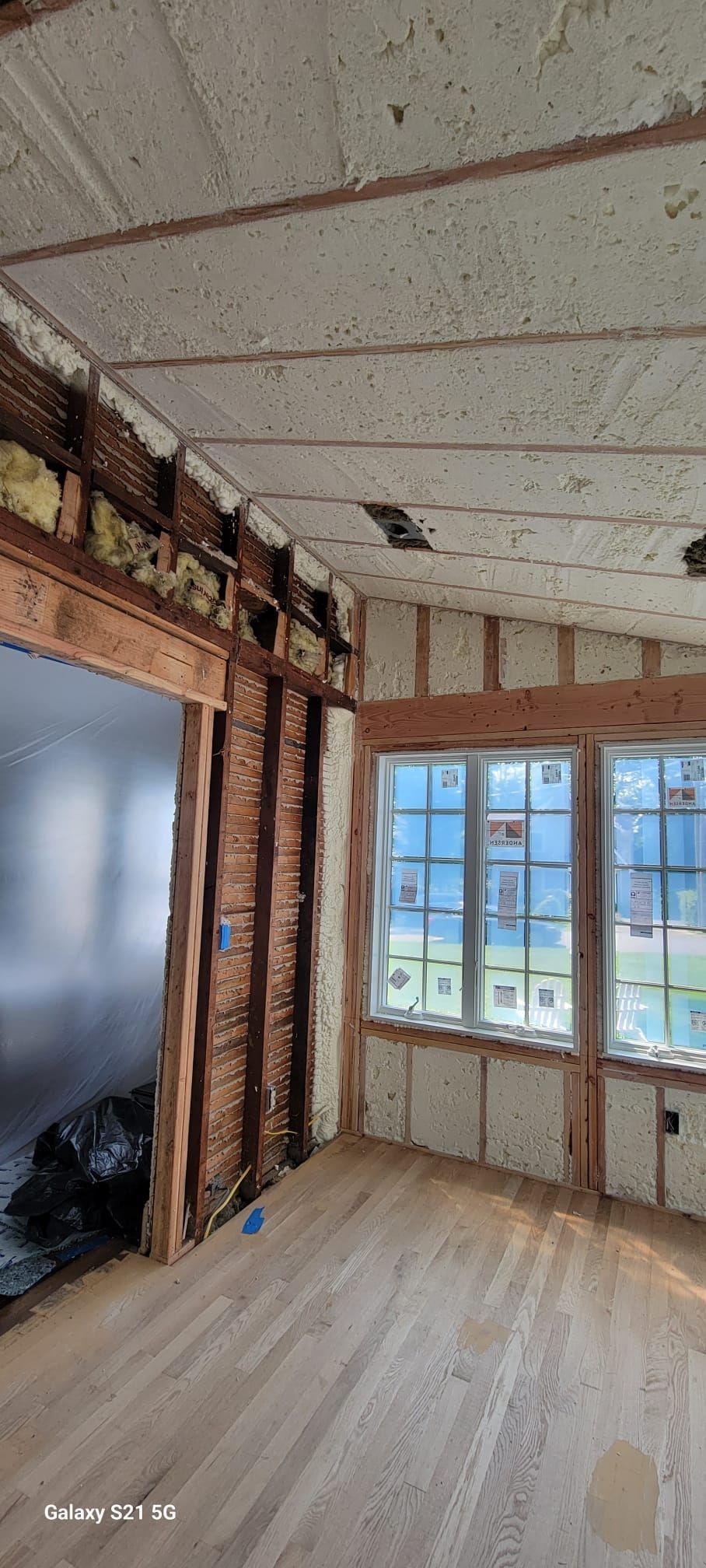 A room with a wooden floor and a ceiling that is being remodeled.