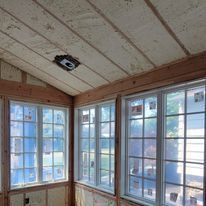 A room with a lot of windows and a wooden ceiling.