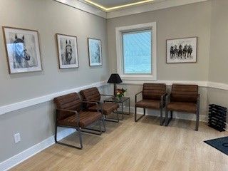 A waiting room with a lot of chairs and pictures on the wall