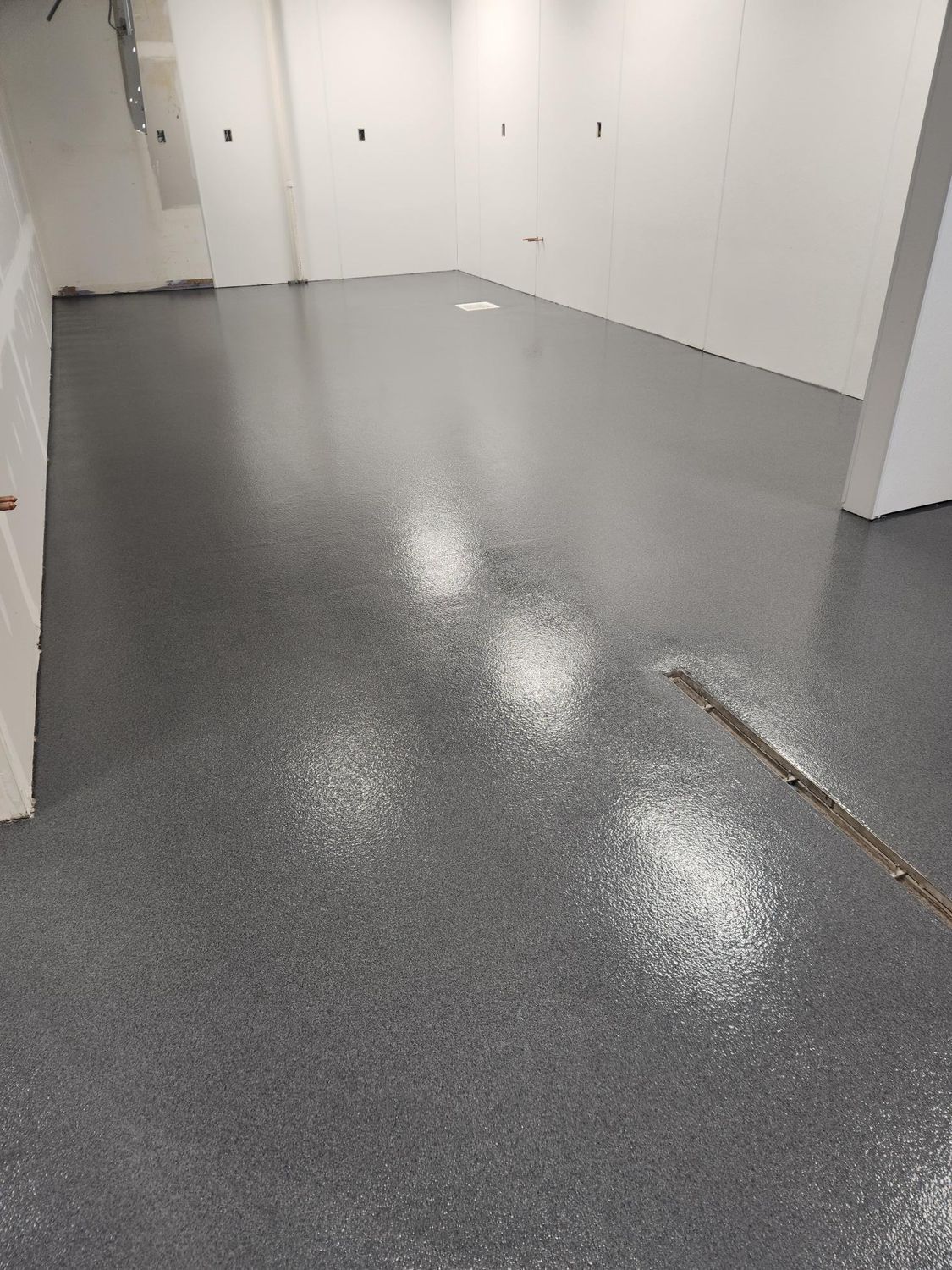 A room with a gray floor and white walls.