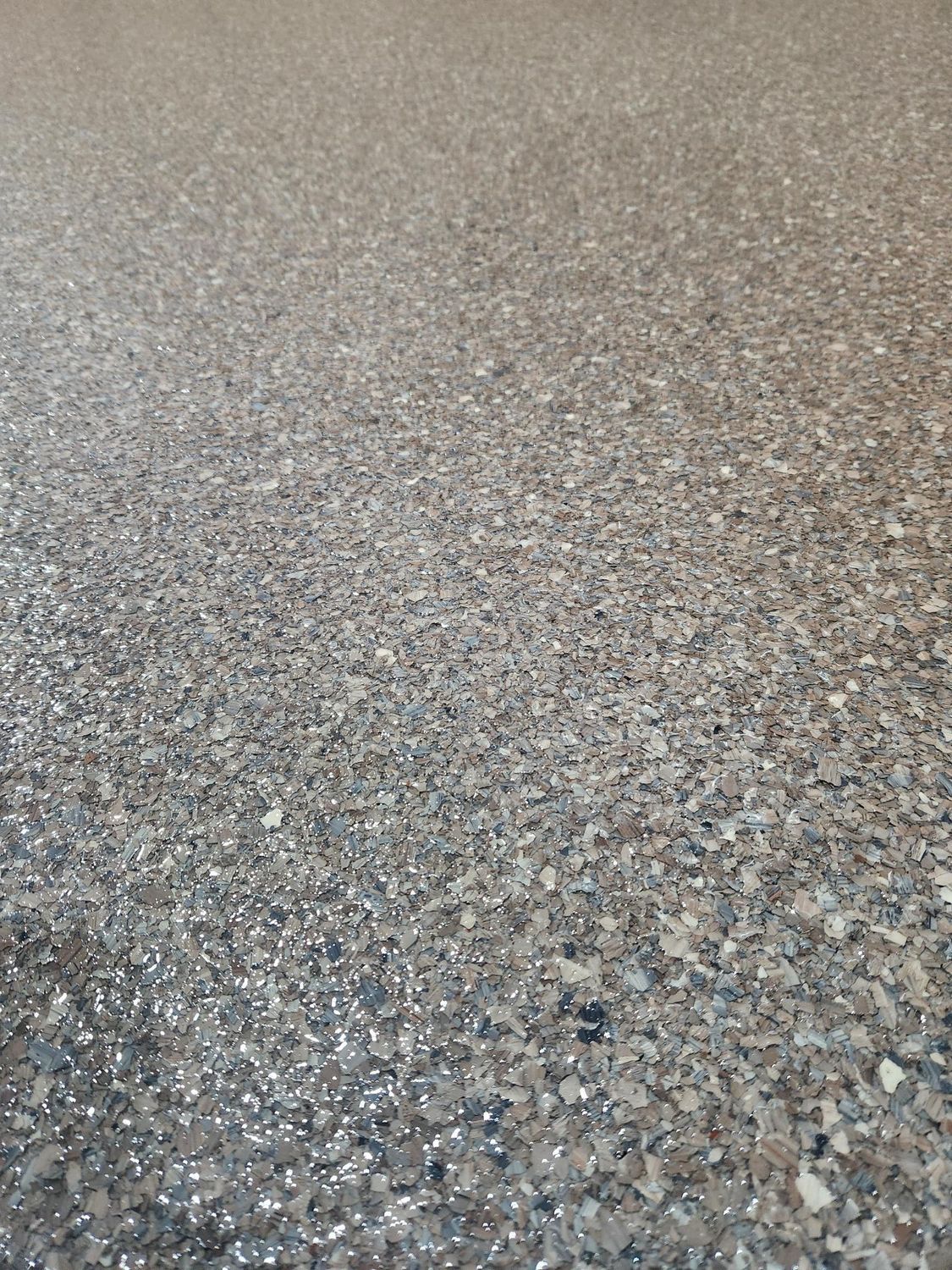 A close up of a concrete floor with a lot of small rocks on it.