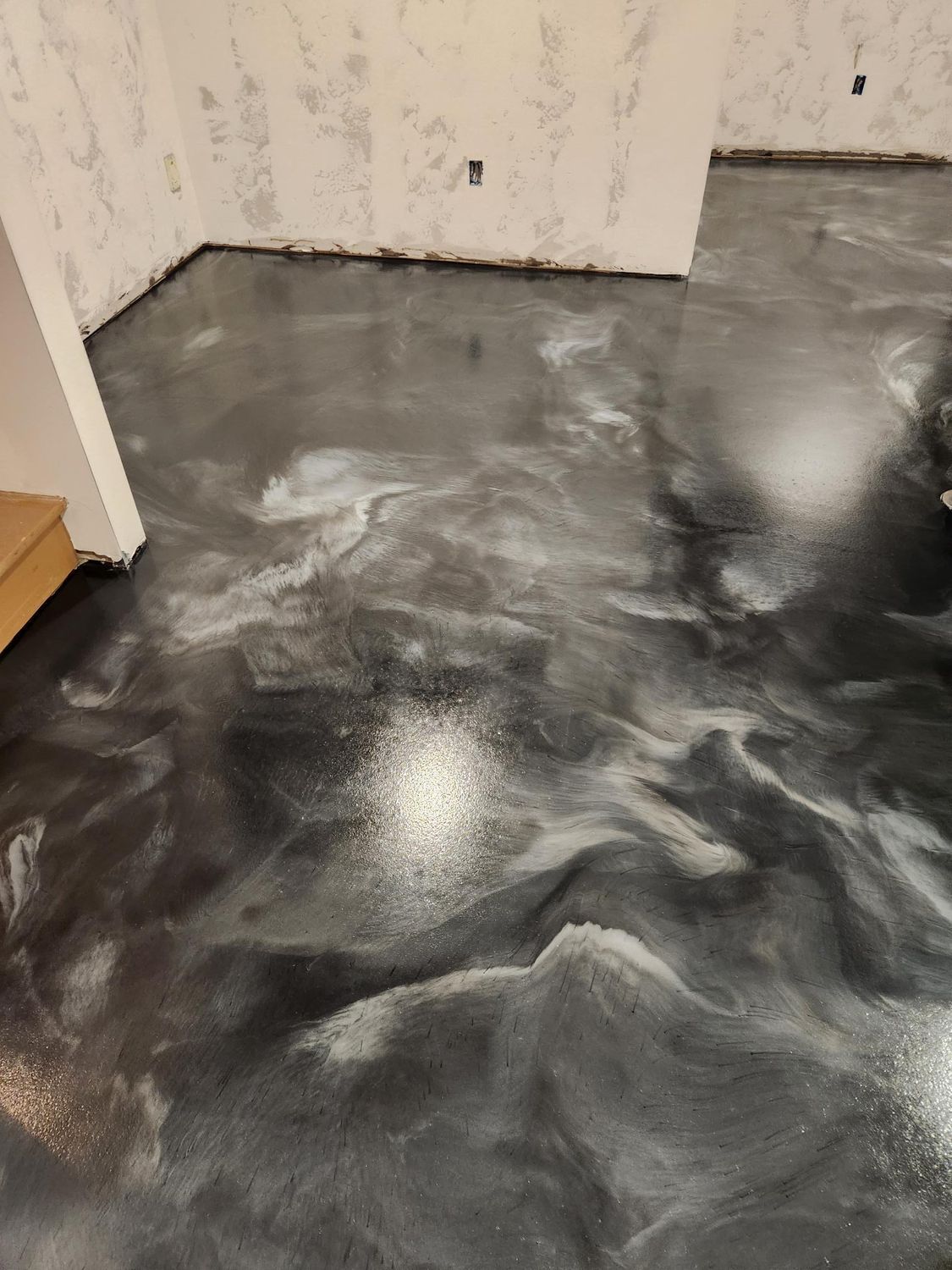 A black and white metallic floor in a room with stairs.