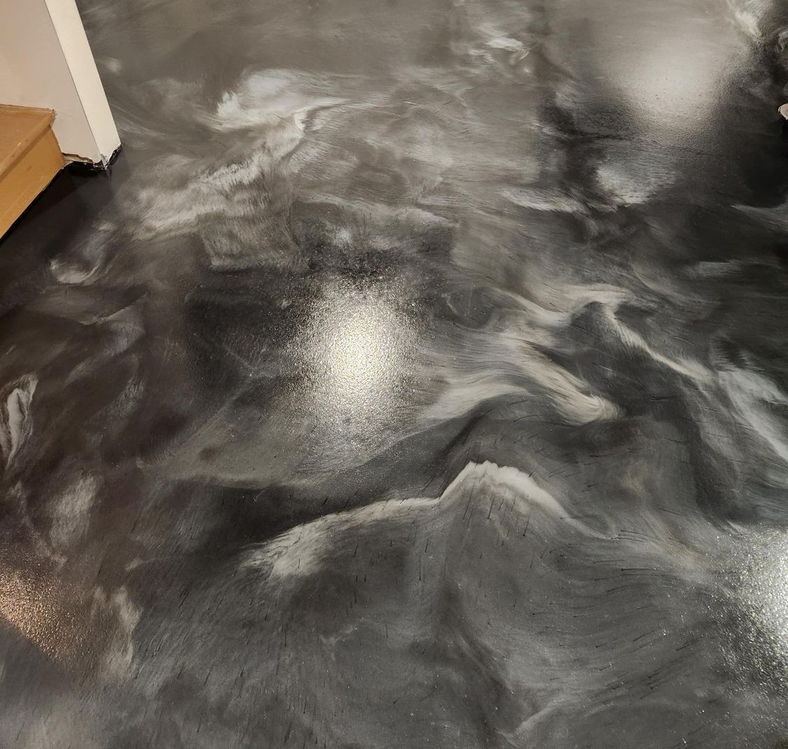 A black and white marble floor with a staircase in the background.