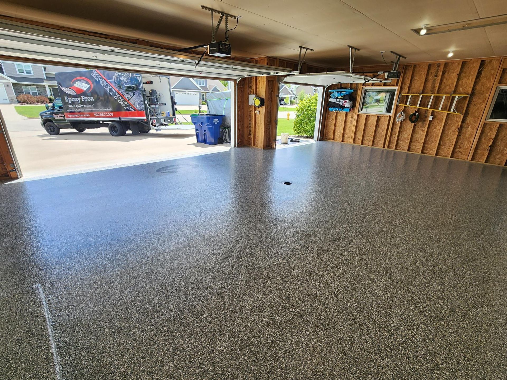 A truck is parked in a garage with the door open.