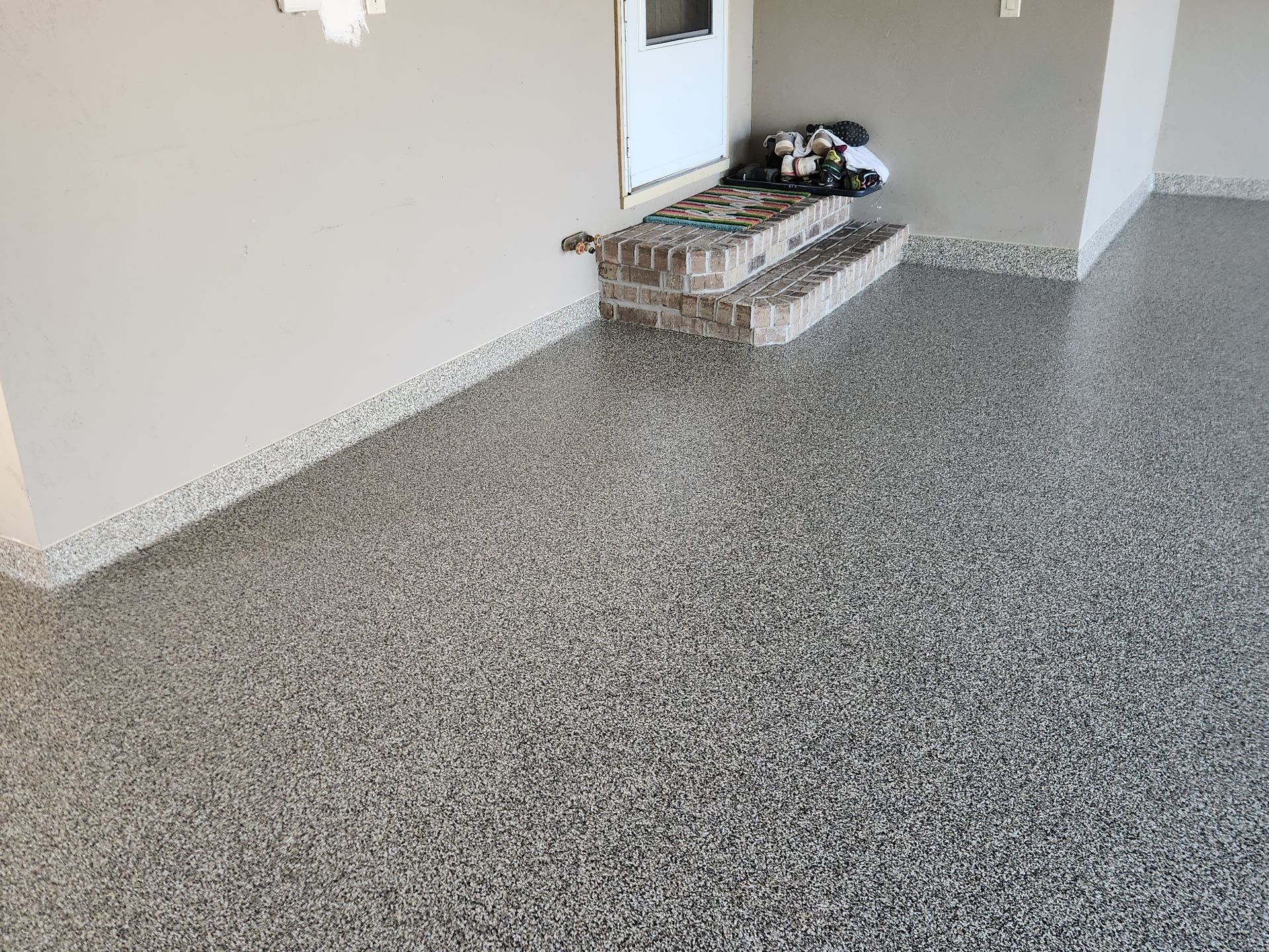 A garage with a concrete floor and stairs leading to it.