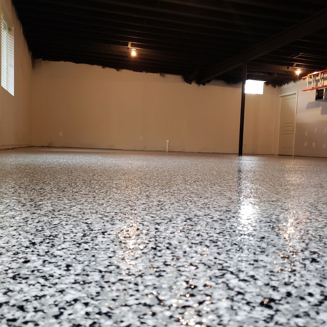 A large empty room with a shiny floor and a window.