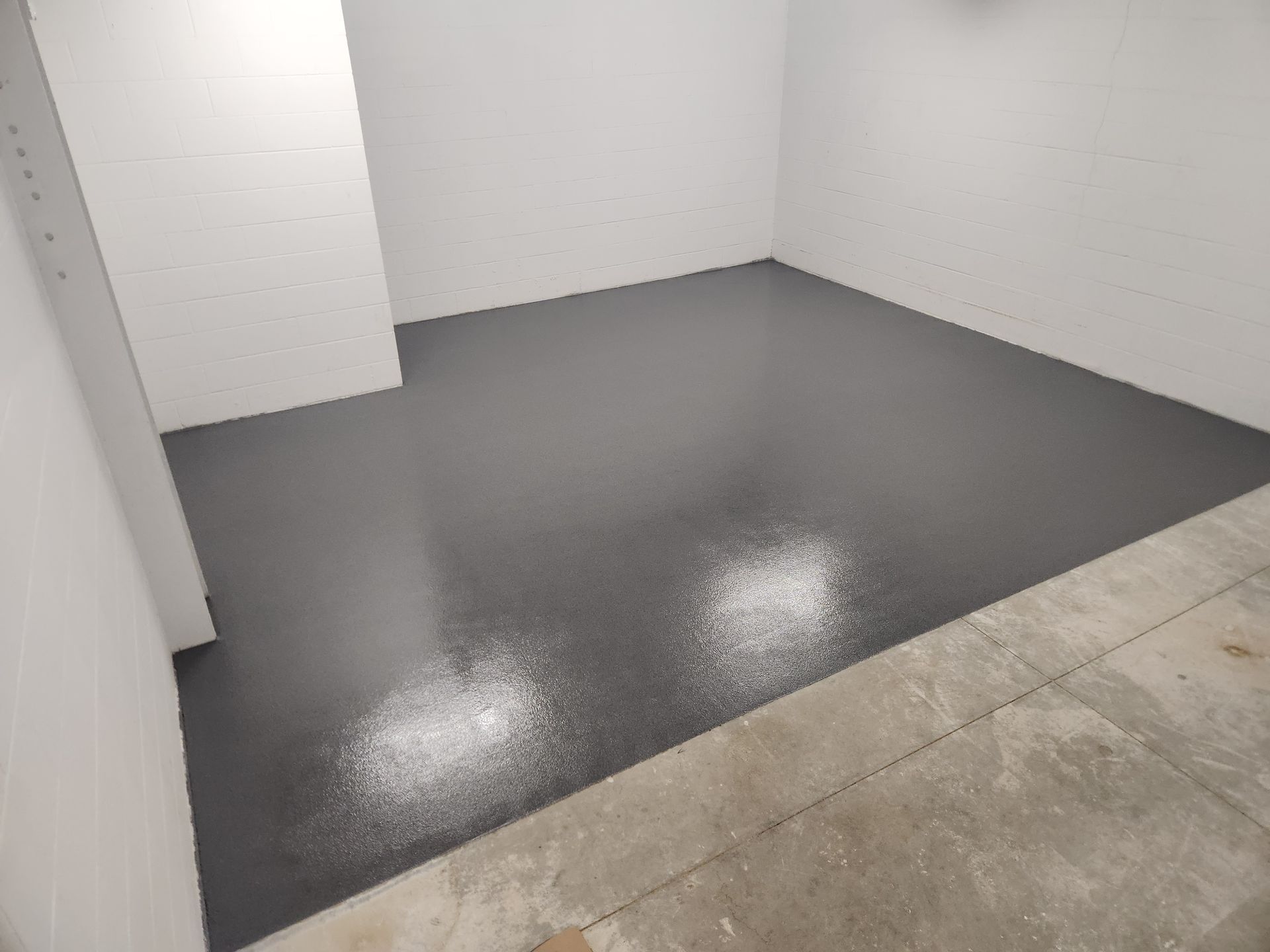 A room with a black floor and white walls.