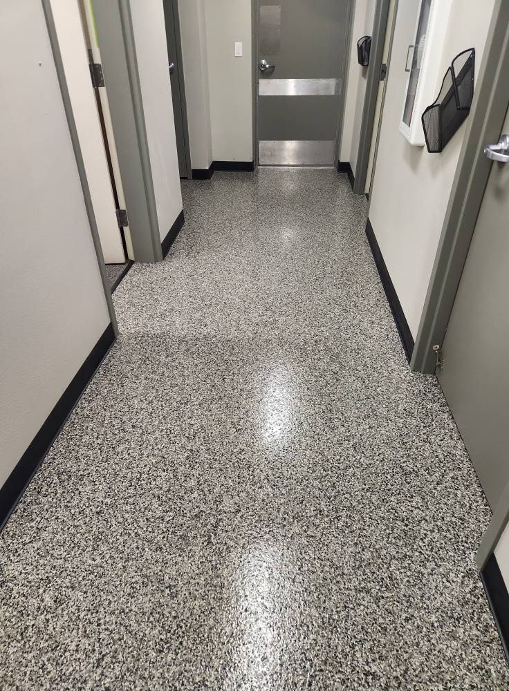 A long hallway with a shiny floor and a door.