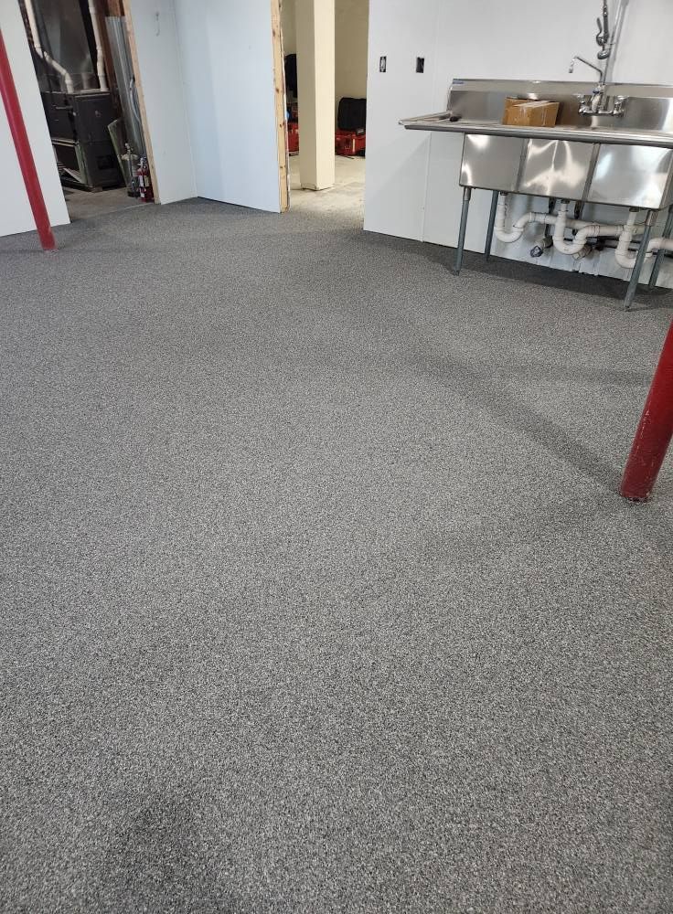 A kitchen with a sink and a gray floor.