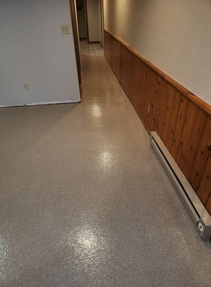 A long hallway with a wooden wall and a white floor.