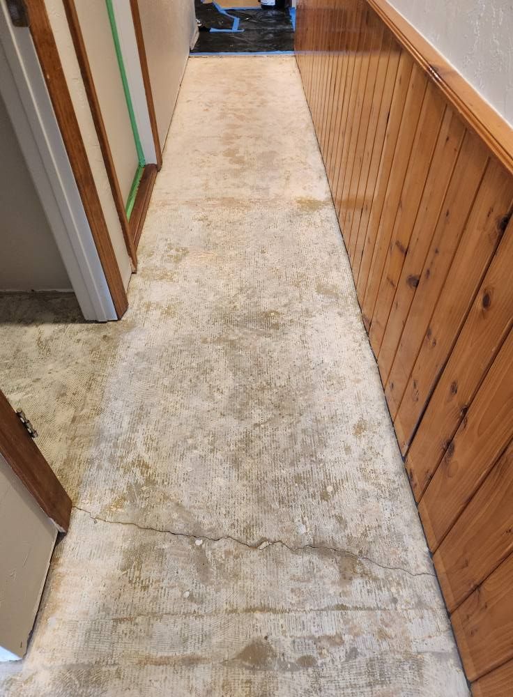 A hallway with a tile floor and wooden walls.