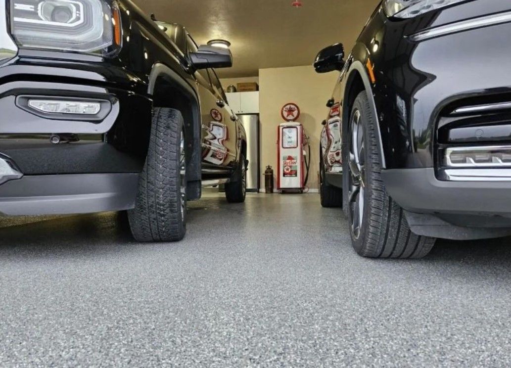 Two black cars are parked next to each other in a garage.