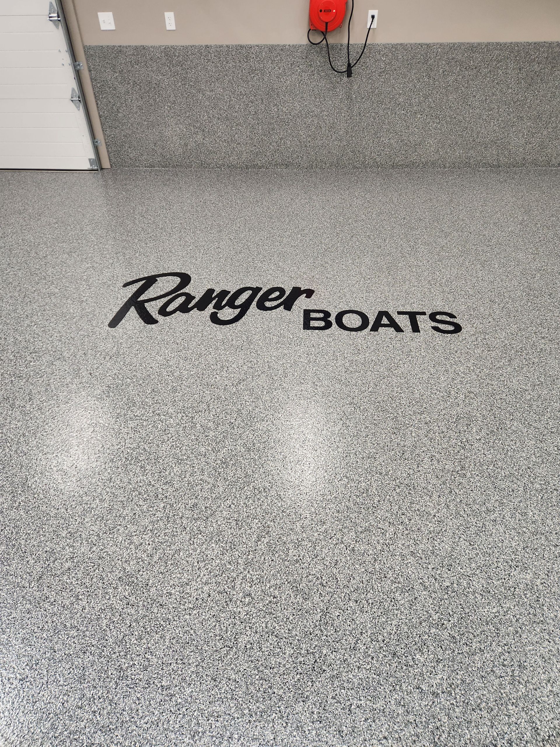 A garage floor with a ranger boats logo on it.