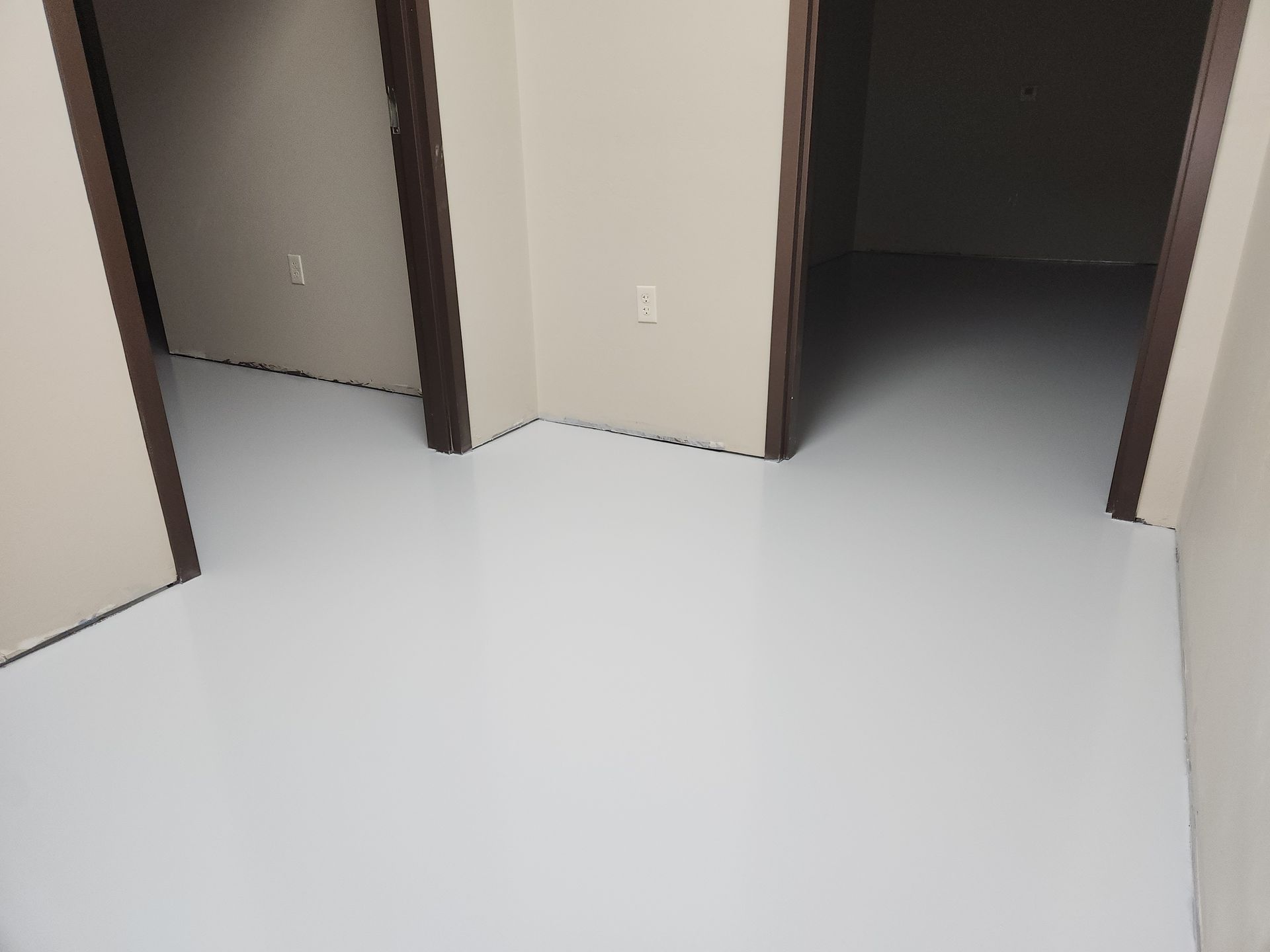 A white floor in a room with two doors