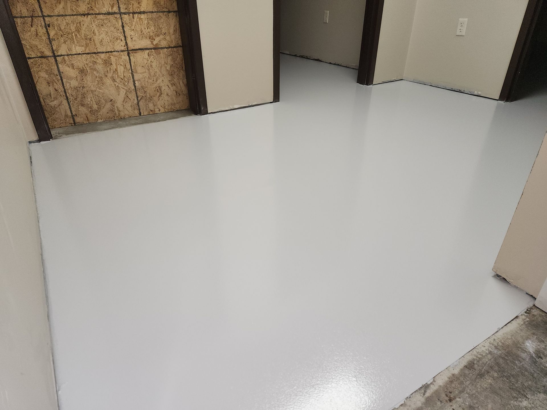 A white floor in a room next to a door.