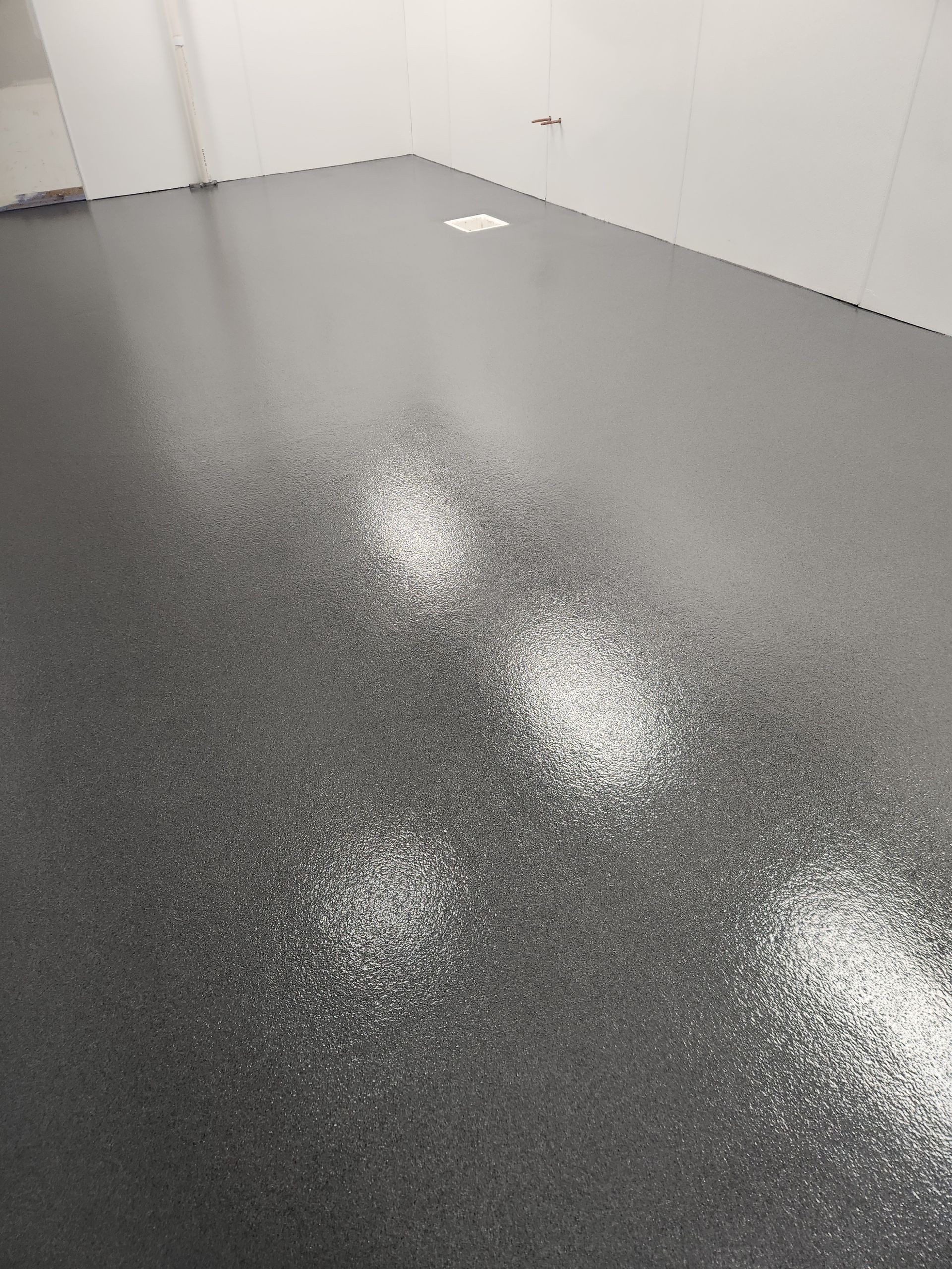 A close up of a shiny black floor in a room.