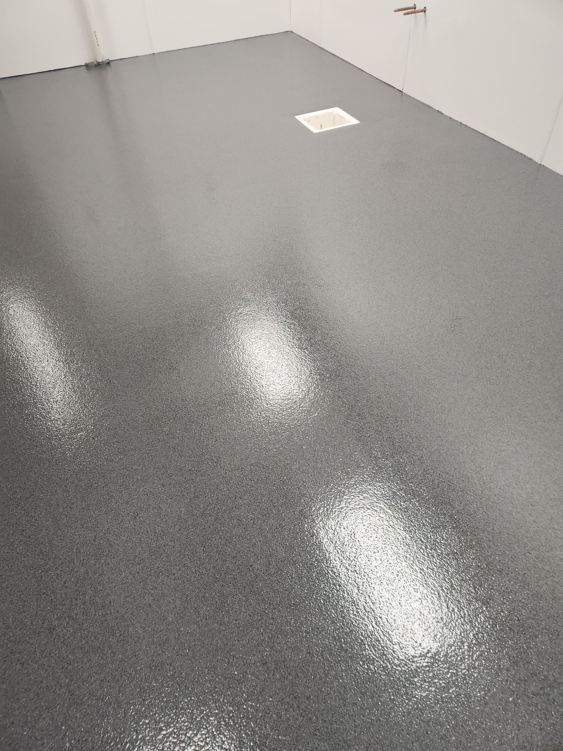 A close up of a shiny gray floor in a room.