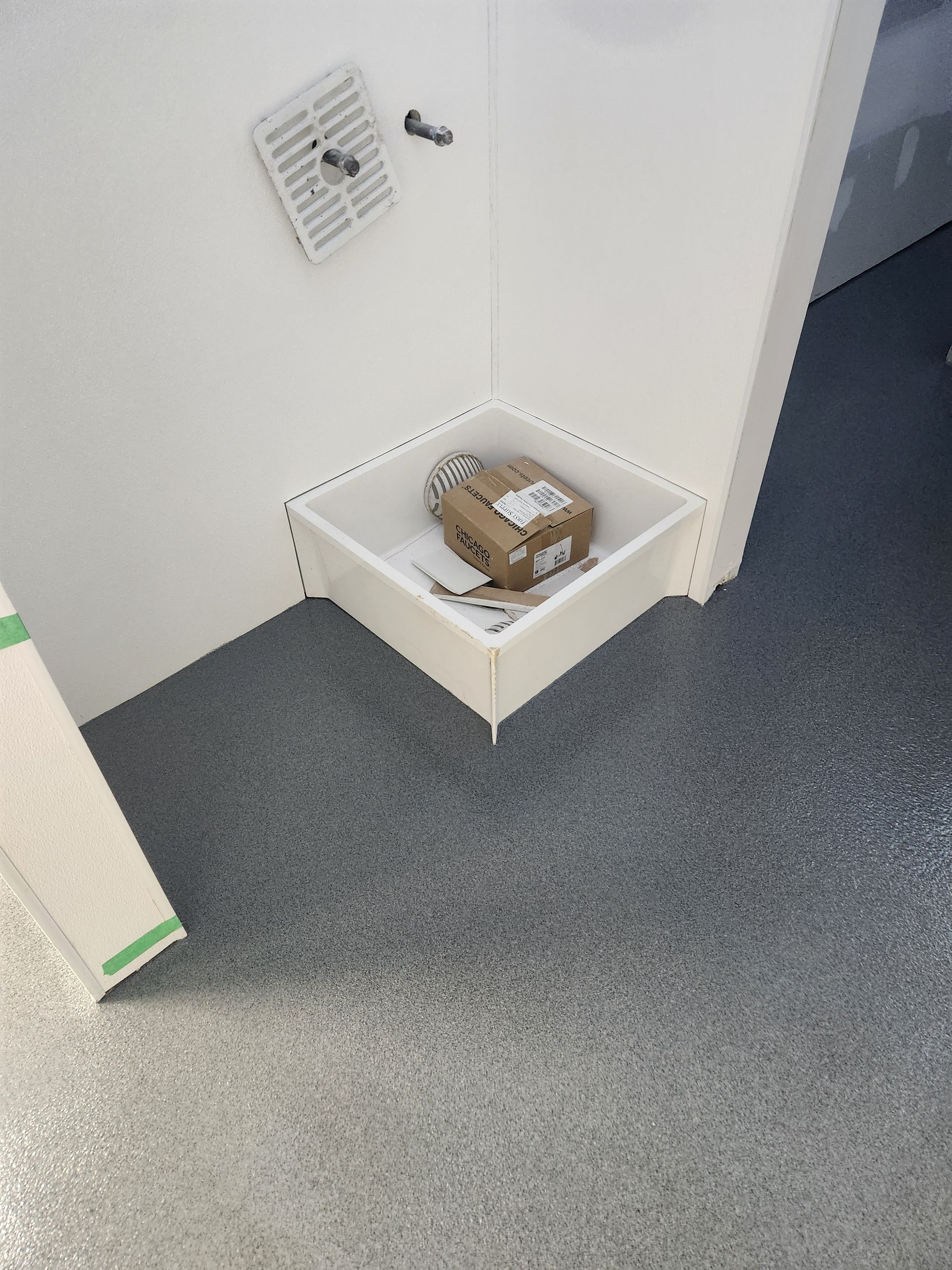 A box is sitting in a corner of a room.