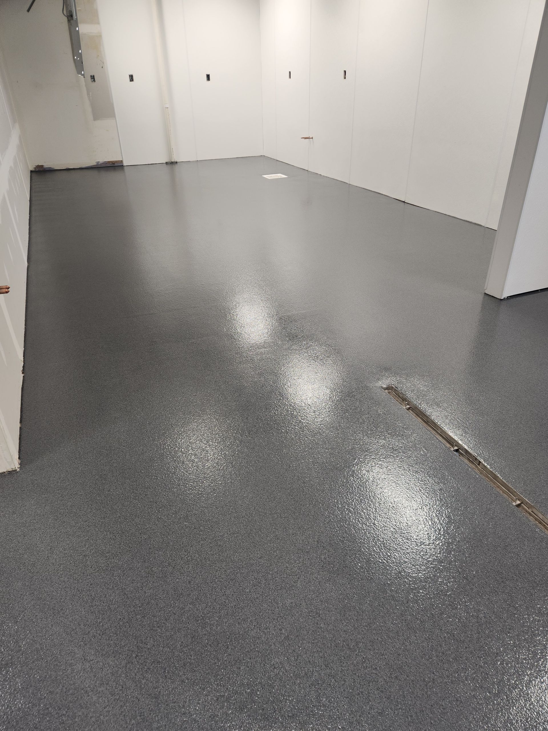 A room with a gray floor and white walls.