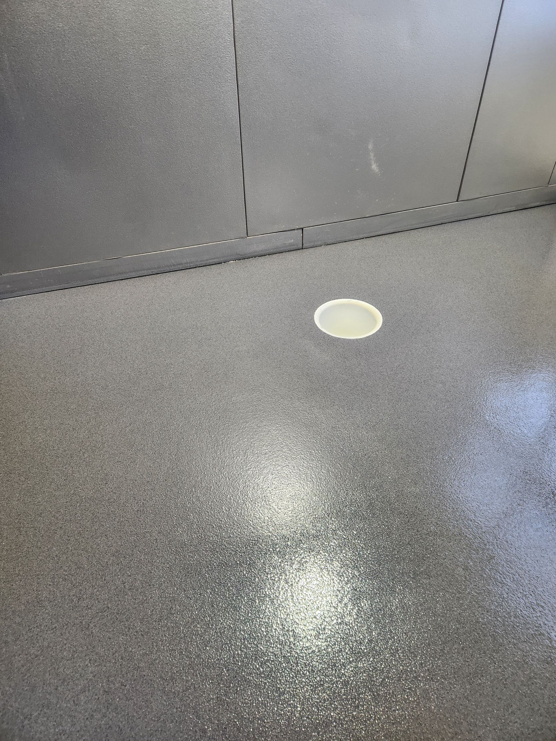A gray floor with a white hole in the middle