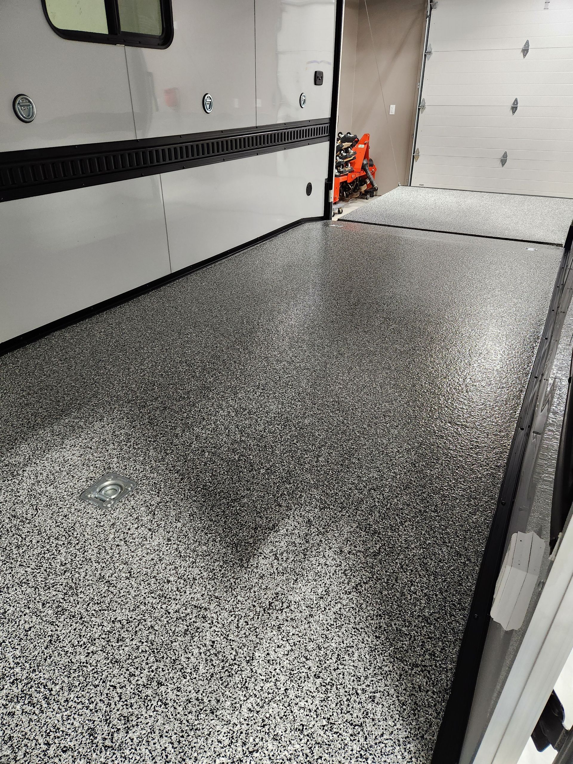 A garage with a concrete floor and a garage door.