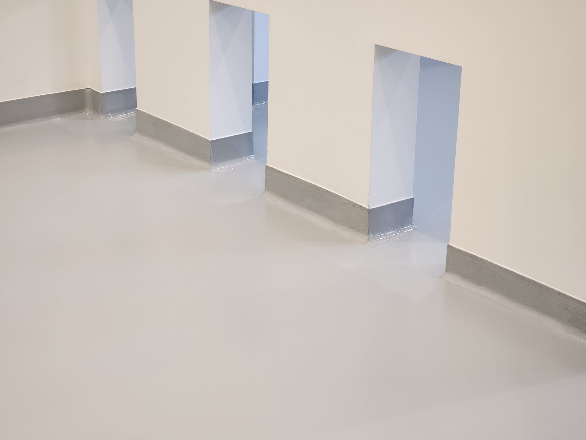 A room with a gray floor and white walls.