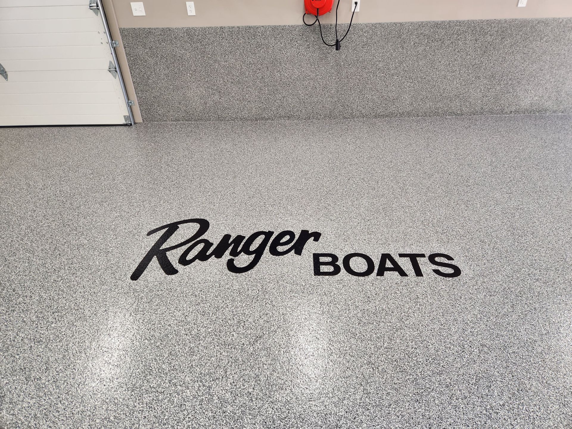 A garage floor with a ranger boats logo on it.