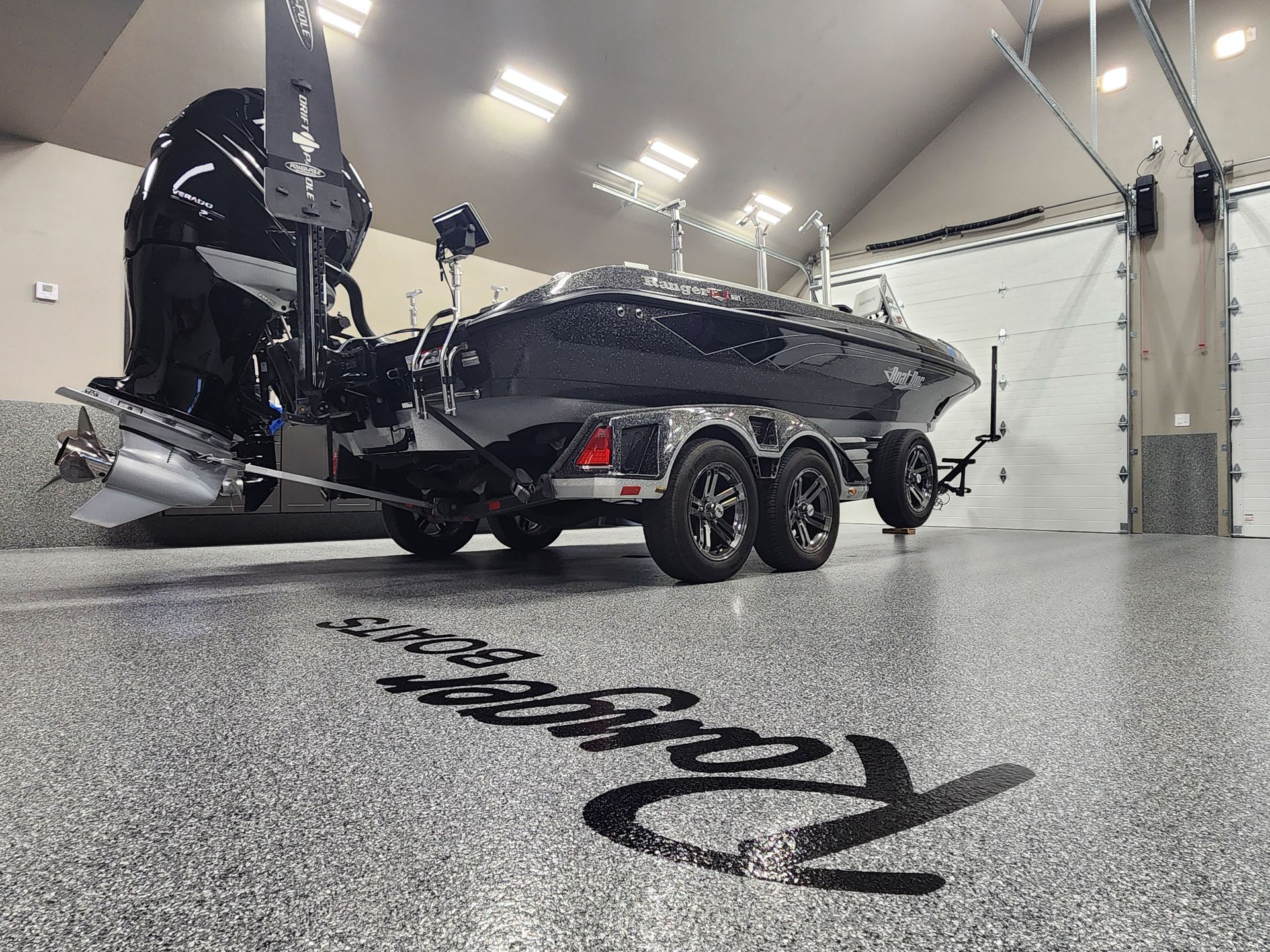 A boat is parked in a garage with a trailer attached to it.
