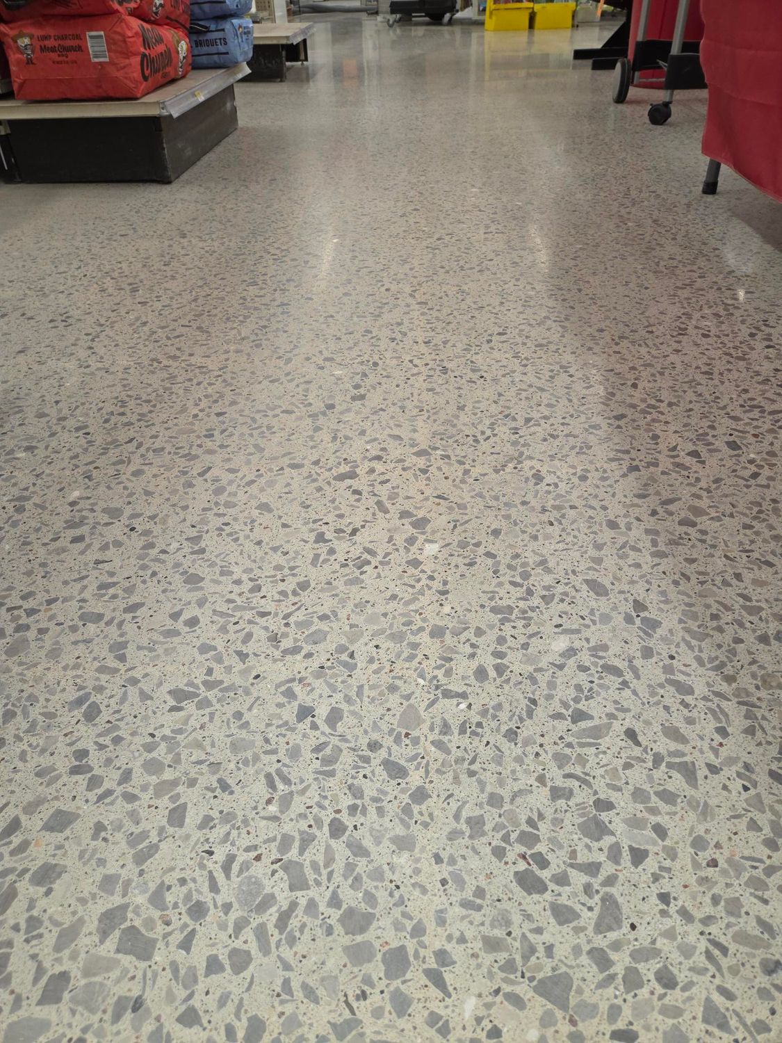 A perspective view of a polished light gray speckled terrazzo floor inside a retail store