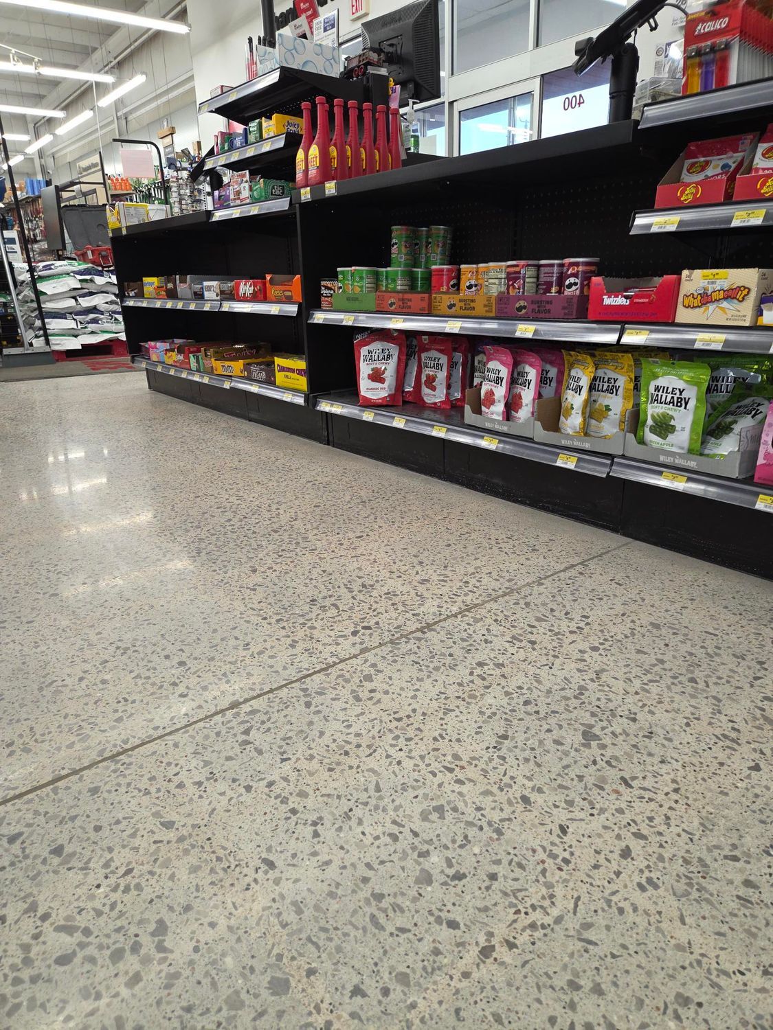 Grocery store aisle with shelves of colorful snack boxes and a speckled floor