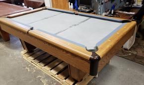 A set of seven translucent red polyhedral dice filled with gold flakes, arranged on a dark, textured surface.