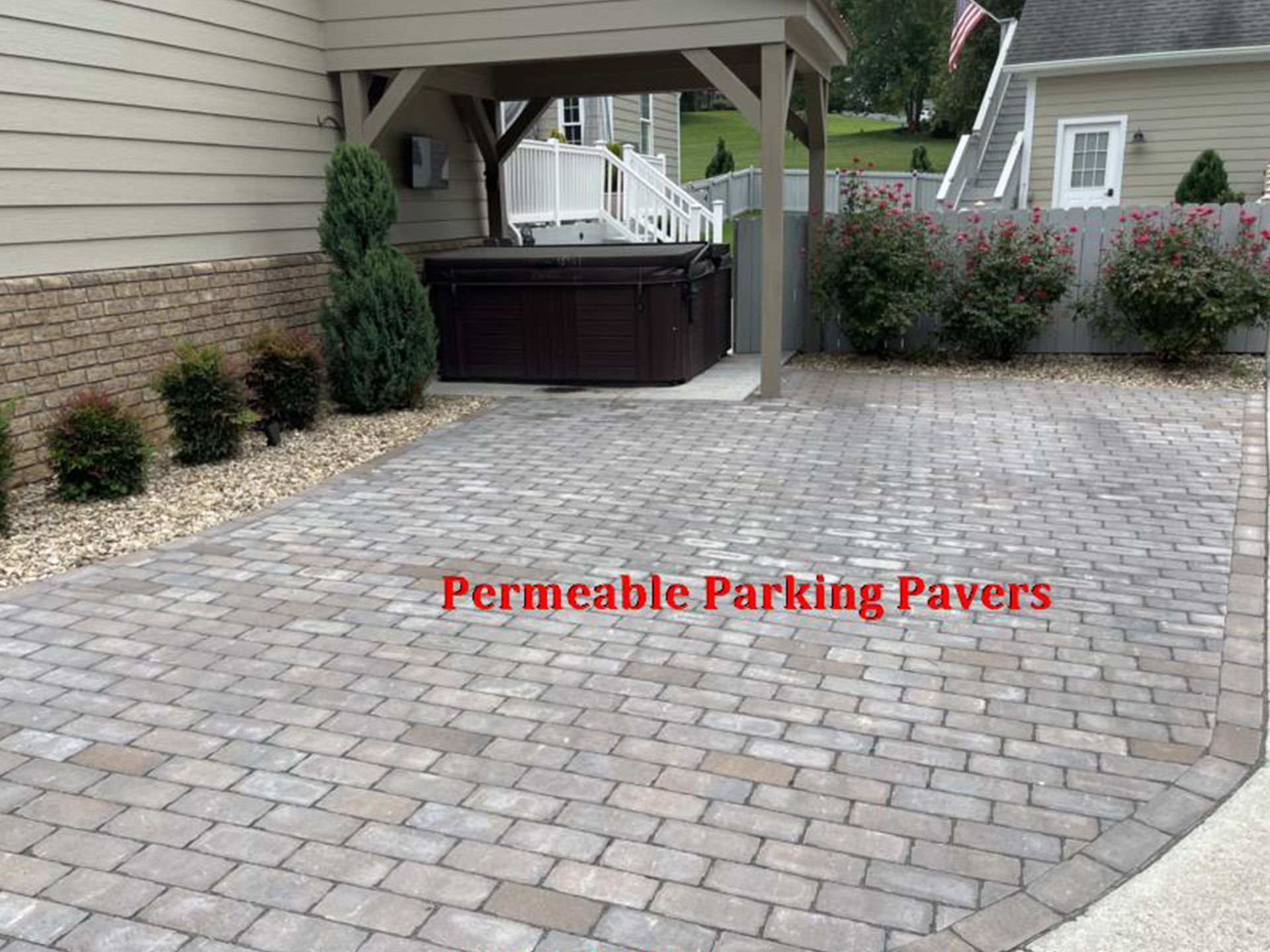 Permeable parking pavers in driveway, with hot tub under a pergola, near a house with landscaping.