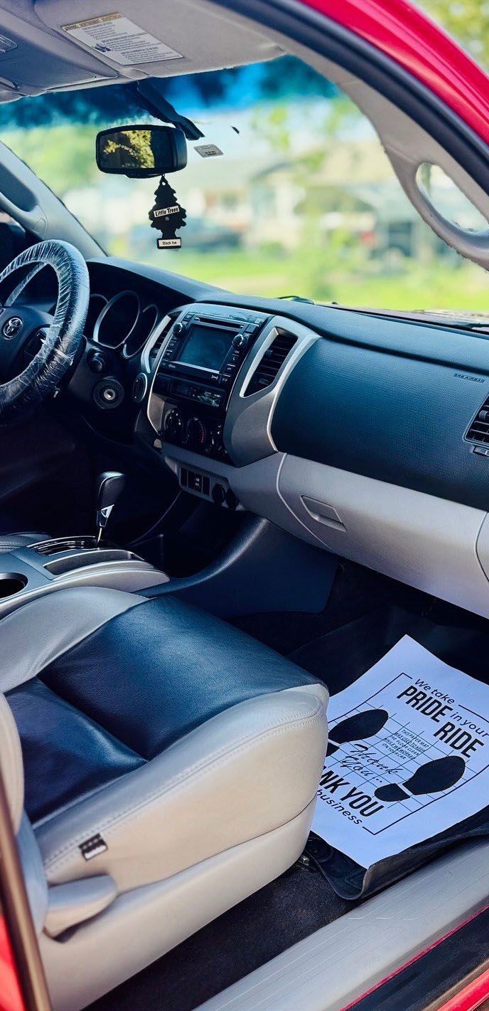 Interior view of a red Toyota Tacoma truck with a black and gray interior. A 