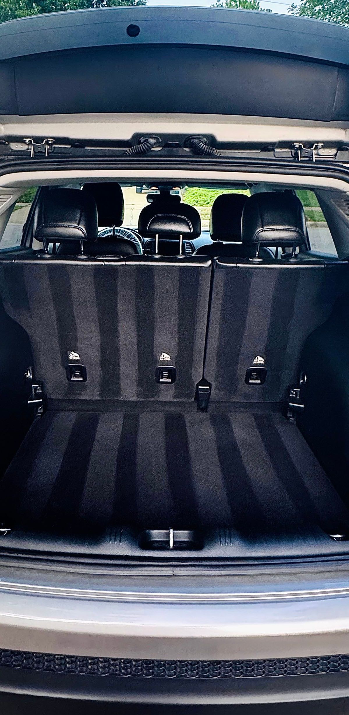 Clean car trunk interior with vertical striped carpet and rear seats.