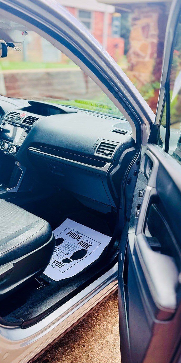 Interior of a silver car with the door open, showing the dashboard, driver's seat, and a 