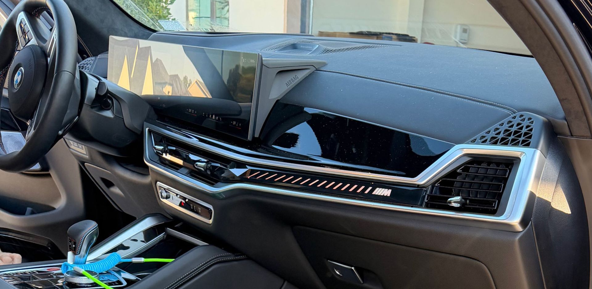 Interior view of a BMW dashboard with a large central screen and a sleek, modern design.