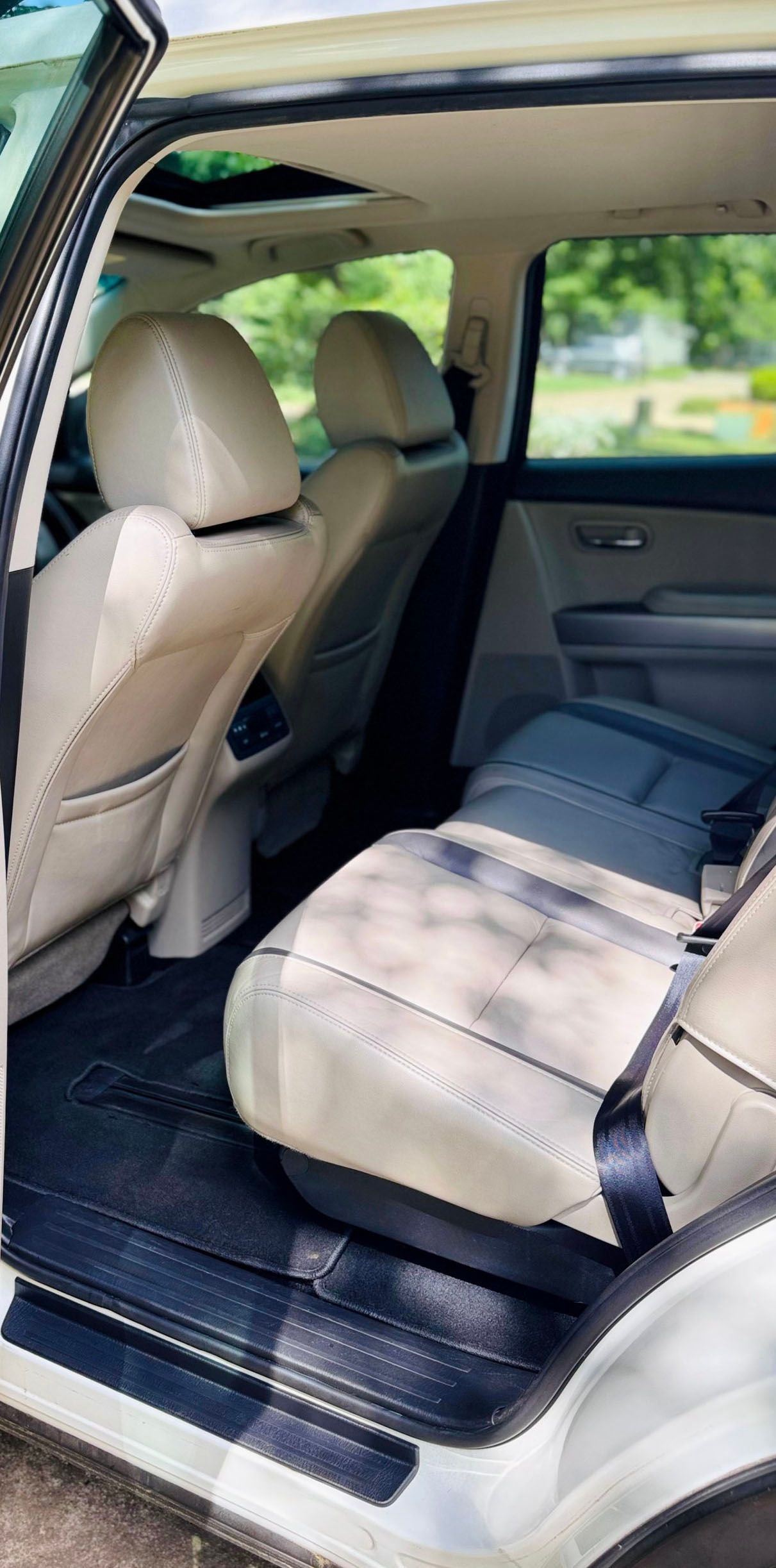 Interior view of a beige-colored SUV with a rear seat and a sun roof.